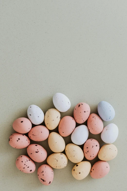 a pile of small eggs sitting on top of a table, a colorized photo, pexels contest winner, pastel pink concrete, candy decorations, background image, programming