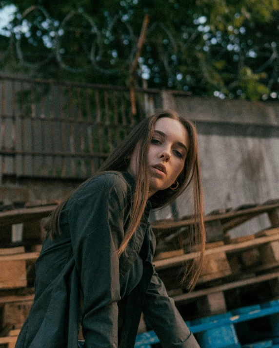 a woman riding a skateboard on top of a wooden ramp, an album cover, inspired by Elsa Bleda, trending on pexels, realism, portrait androgynous girl, looking serious, portrait sophie mudd, standing in a dark alleyway