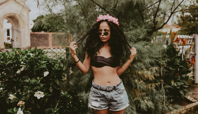 a woman with a flower in her hair posing for a picture, pexels contest winner, croptop and shorts, in a black betch bra, trending on vsco, the flower crown