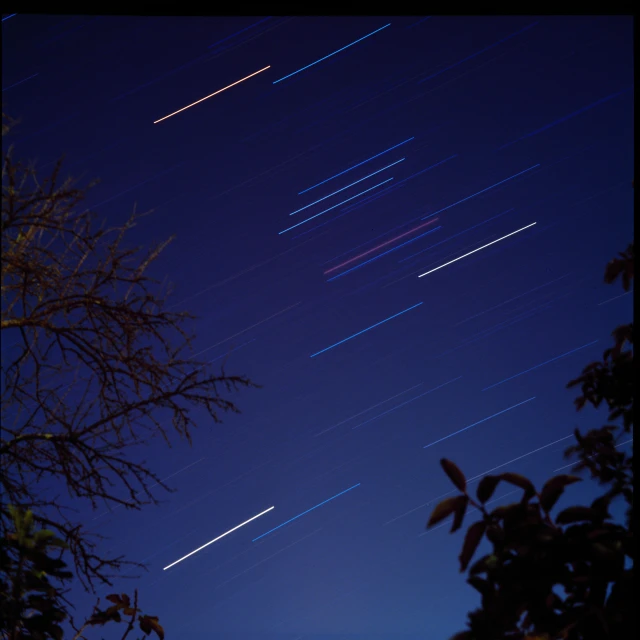 a long exposure of star trails in the night sky, an album cover, flying spaceships, shot on hasselblad, 300mm, f/3.2
