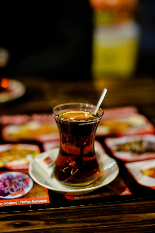 a glass of tea sitting on top of a table, hurufiyya, square, nightlife, traditional medium, photograph taken in 2 0 2 0