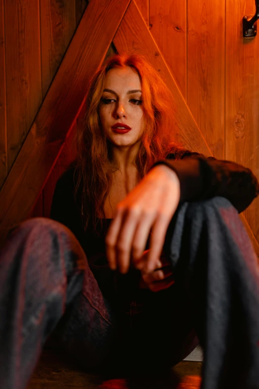 a woman sitting on the floor in a room, a portrait, inspired by Elsa Bleda, trending on pexels, antipodeans, high red lights, stood outside a wooden cabin, mara jade, woman in streetwear