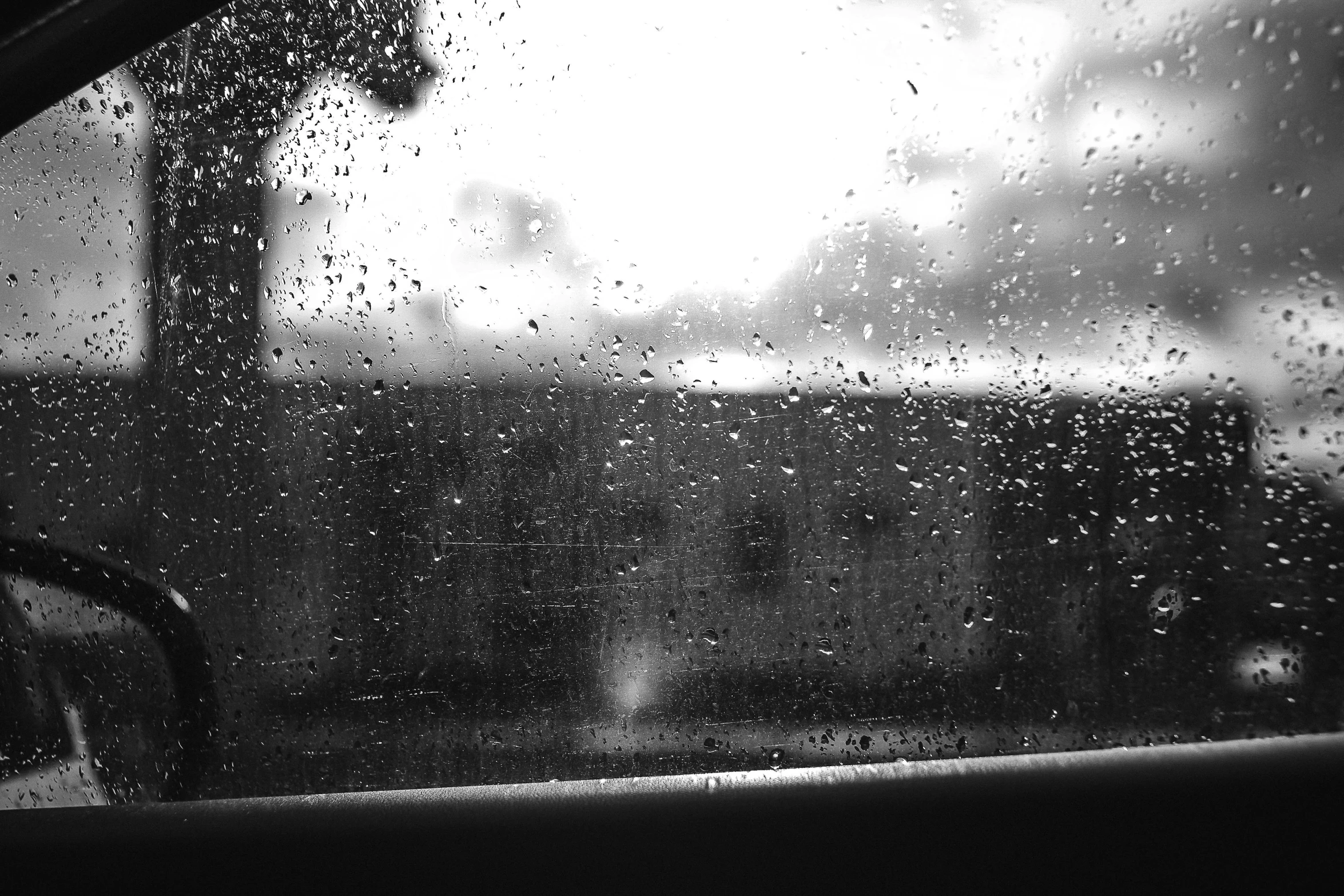 a black and white photo of a car in the rain, a black and white photo, pexels, conceptual art, train window, artwork empty daylight, drips, black and white color aesthetic