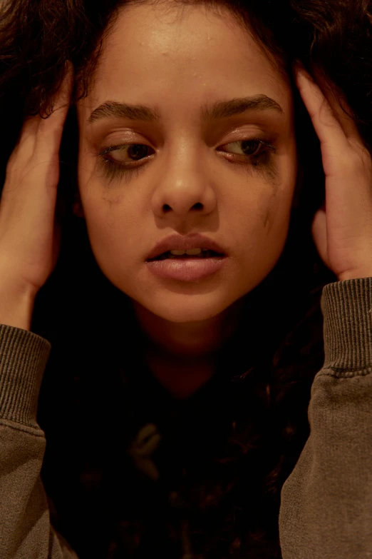 a woman holding her head in her hands, inspired by Nan Goldin, instagram, renaissance, tessa thompson, film still from a horror movie, black eyes and large forehead, hollywood promotional image