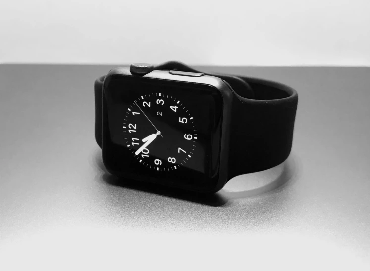 a close up of a wrist watch on a table, a black and white photo, by Adam Marczyński, pixabay, minimalism, apple design, black plastic, square, gamer