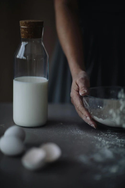 a person holding a bowl of flour next to a bottle of milk, a still life, unsplash, cinematic still frame, multiple stories, ignant, laura watson