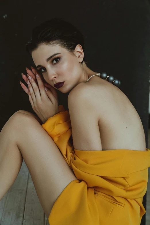 a woman in a yellow dress sitting on a wooden floor, a colorized photo, inspired by Elsa Bleda, trending on pexels, mannerism, 🤤 girl portrait, hands behind her body pose!, young beautiful amouranth, yellow robe