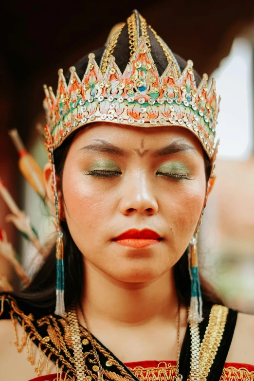 a close up of a person wearing a crown, an album cover, inspired by I Ketut Soki, trending on pexels, sumatraism, young himalayan woman, aztec, prideful look, beautiful surroundings