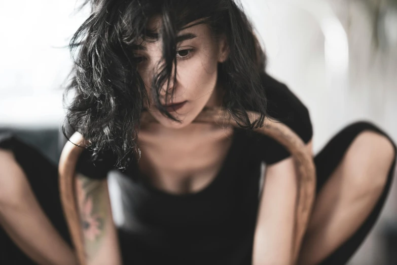 a woman sitting on top of a black couch, trending on pexels, antipodeans, messy hair bedhead, septum piercing, woman with black hair, charli bowater and artgeem