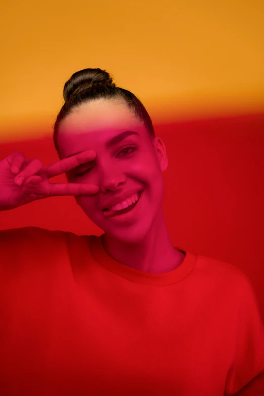 a woman in a red shirt covering her eyes, an album cover, pexels contest winner, antipodeans, hailee steinfeld, glowing rainbow face, topknot, dramatic smiling pose