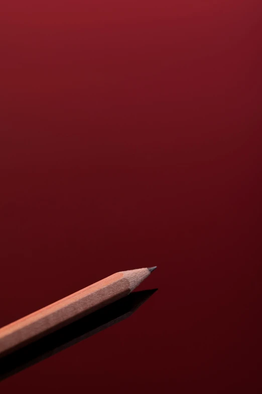 a close up of a pencil with a red background, unsplash, hyperrealism, wine red trim, clemens ascher, very emotional, maroon