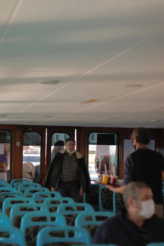 a bunch of people that are sitting in a bus, interior of staten island ferry, he's on an old sailing boat, tehran, low quality photo