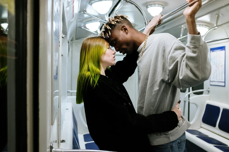 a man standing next to a woman on a train, inspired by Nan Goldin, trending on pexels, graffiti, bright green hair, playboi carti and lil uzi vert, making love, a blond