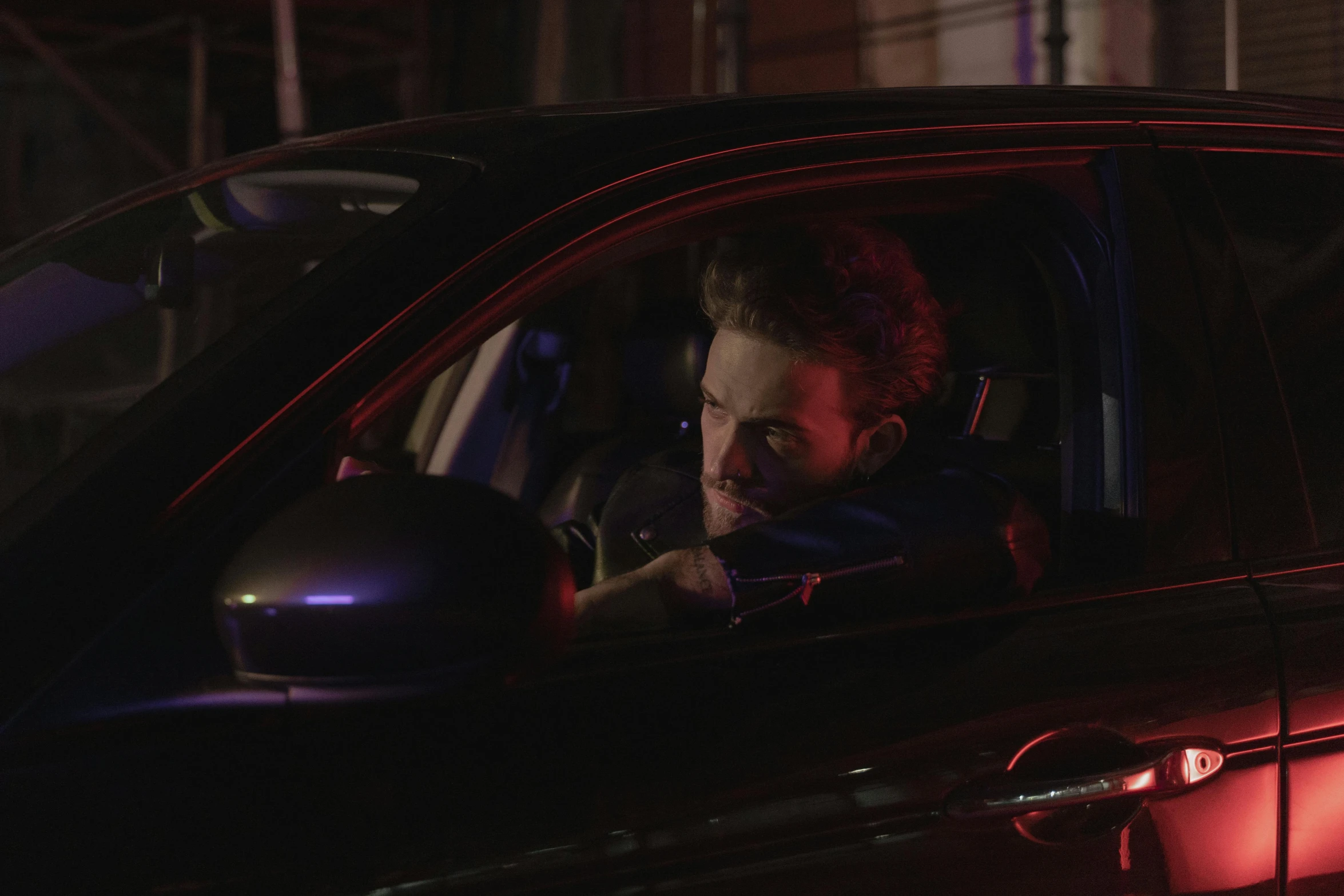 a man sitting in the passenger seat of a car, by Elsa Bleda, pexels contest winner, photorealism, film still of ryan reynolds, running lights, xqc, official music video