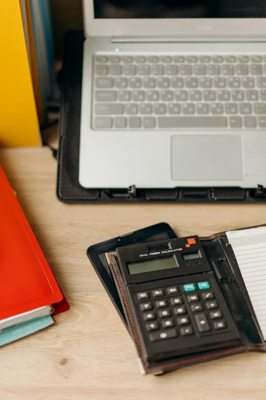 a laptop computer sitting on top of a desk next to a calculator, academic art, thumbnail, educational supplies, multiple stories, middle shot