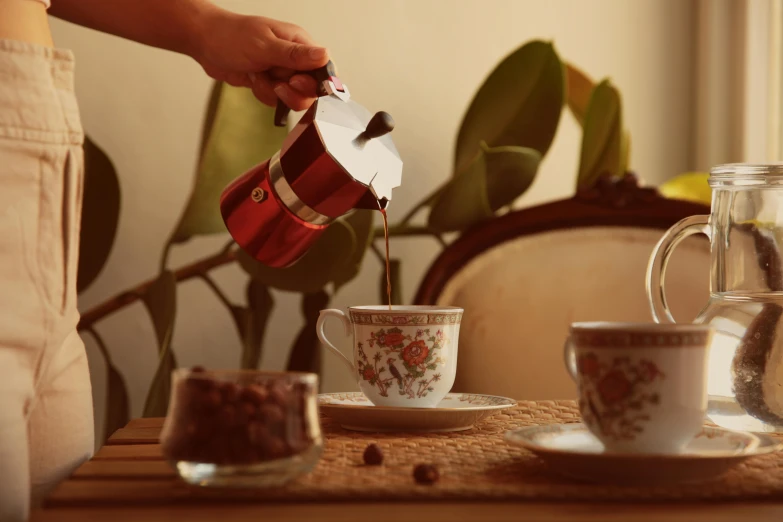 a person pouring coffee into cups on a table, a still life, by Julia Pishtar, easy to use, “ iron bark, brown, moroccan