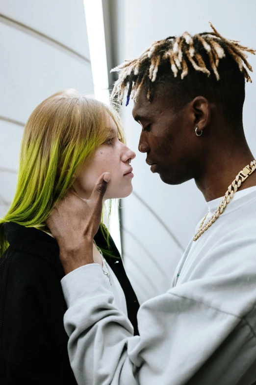 a man and a woman standing next to each other, trending on pexels, visual art, bright green hair, black teenage boy, making out, blonde man