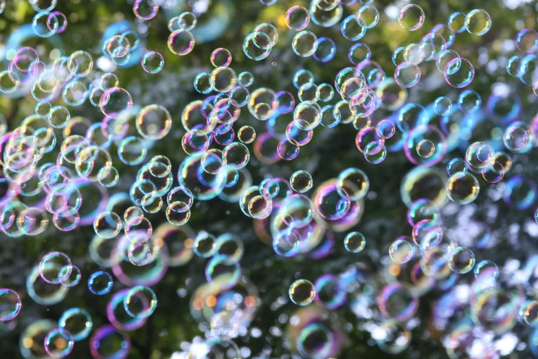 a bunch of soap bubbles floating in the air, a stipple, inspired by Bruce Munro, pexels, rainbow bubbles, subtle detailing, ilustration, low - angle shot