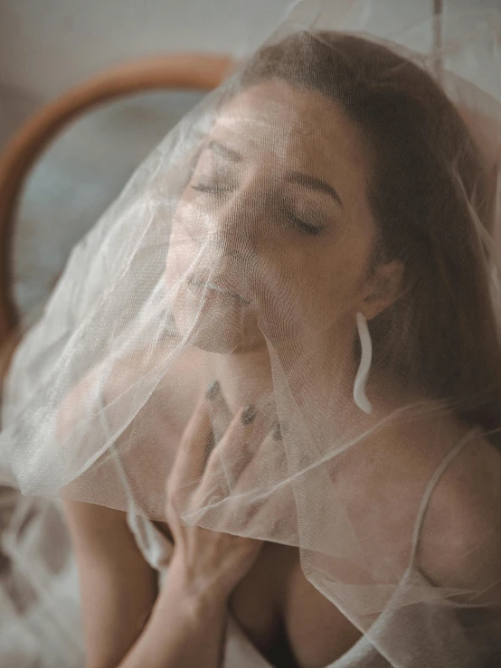 a woman sitting on top of a bed covered in a veil, inspired by Elsa Bleda, trending on unsplash, renaissance, decolletage, white powder makeup, gif, translucent