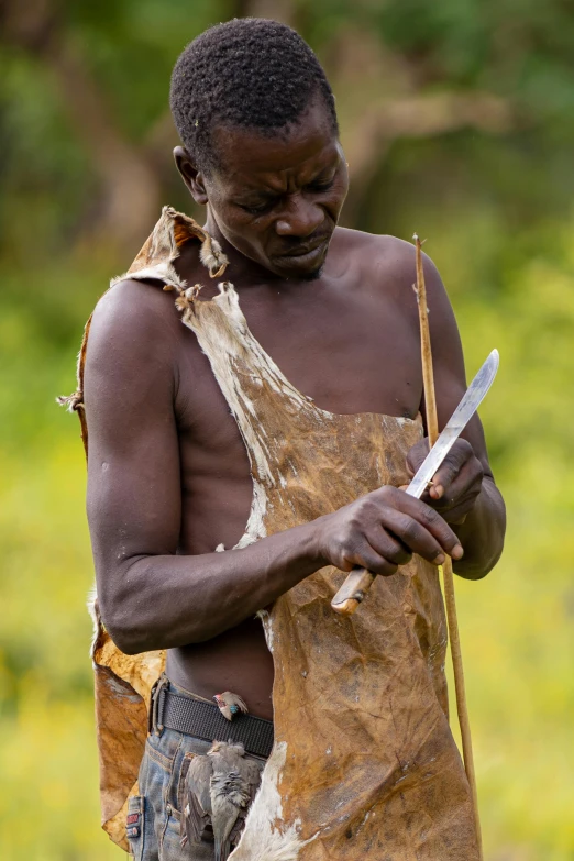 a man standing in a field holding a knife, loin cloth, carefully crafted, sculpting, local conspirologist