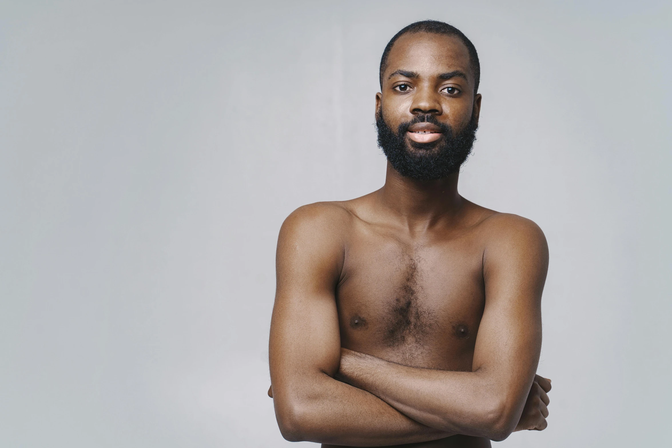 a shirtless man standing with his arms crossed, by Matija Jama, black curly beard, lgbtq, thin aged 2 5, emmanuel shiru