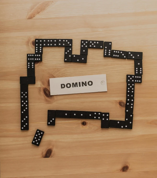 a domino board sitting on top of a wooden table, a cartoon, by Robbie Trevino, pexels contest winner, paul rand, monaco, laser cut, arch