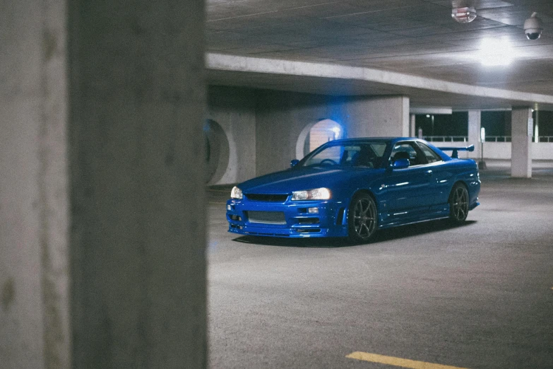 a blue car parked in a parking garage, inspired by Kanō Hōgai, pexels contest winner, cobbled together nissan r34 gtr, portrait of jerma985, inspect in inventory image, garage kit