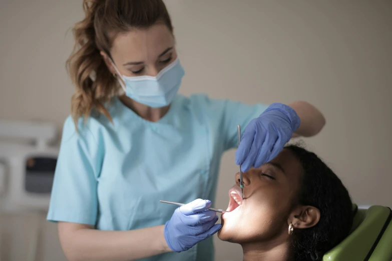 a woman getting her teeth examined by a dentist, a colorized photo, pexels contest winner, hurufiyya, black, thumbnail, small chin, aesthetic shot