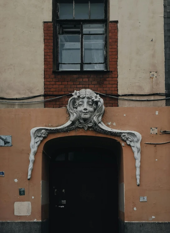 a building with a face on the side of it, by Eamon Everall, pexels contest winner, art nouveau, elaborate ornate head piece, about to enter doorframe, street art 8 k, ireland