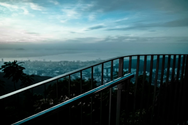 a view of a city from the top of a hill, pexels contest winner, iron railing, cyan, rectangle, low light