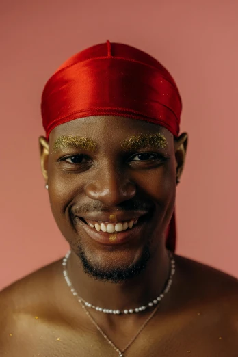 a man in a red turban smiles at the camera, an album cover, inspired by Theo Constanté, trending on pexels, non binary model, smooth golden skin, kano), yasuke 5 0 0 px models
