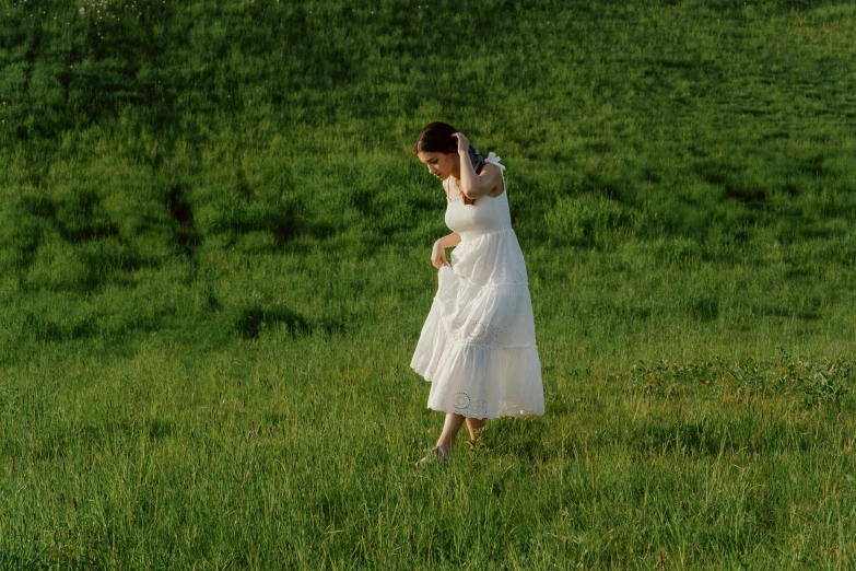 a woman in a white dress standing in a field, inspired by Andrew Wyeth, unsplash, on a green lawn, playing, side view of her taking steps, still from a live action movie