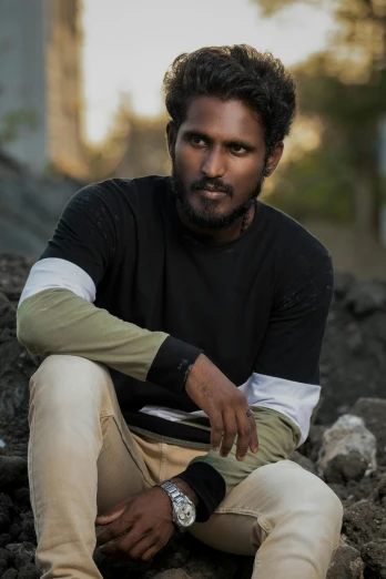 a man sitting on top of a pile of dirt, an album cover, pexels contest winner, romanticism, indian super model, wearing casual clothes, chocolate. rugged, headshot profile picture