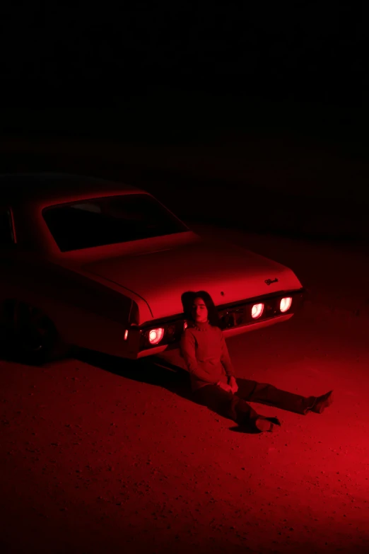 a person sitting on the ground next to a car, an album cover, blood aura red light, ignant, high res photo, square