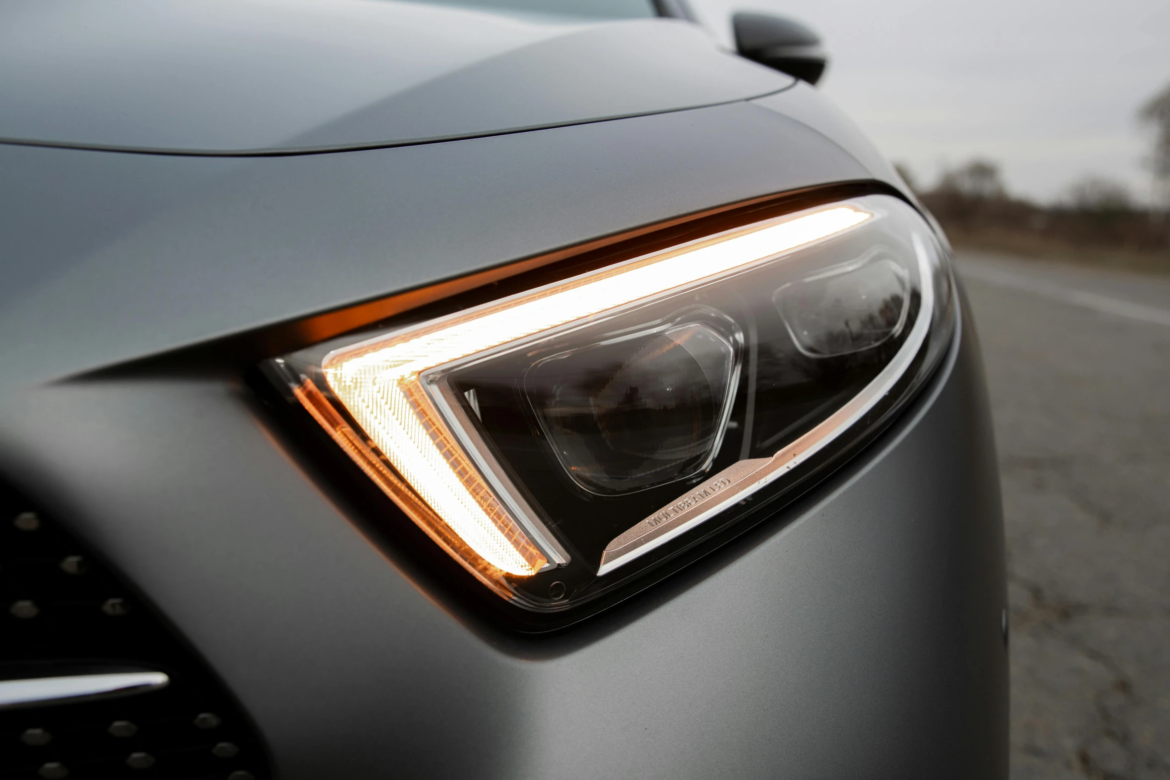 a close up of the headlights of a car, with accurate features, ambient amber light, right side key light, 2 0 % pearlescent detailing