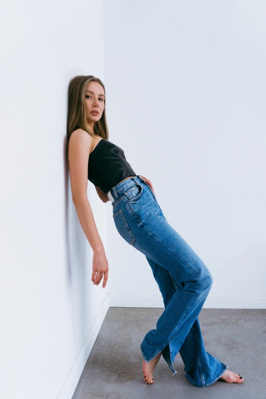 a beautiful young woman leaning against a wall, inspired by Jean Hey, trending on pexels, renaissance, jeans pants, portrait sophie mudd, doing a sassy pose, shoulder-long straight