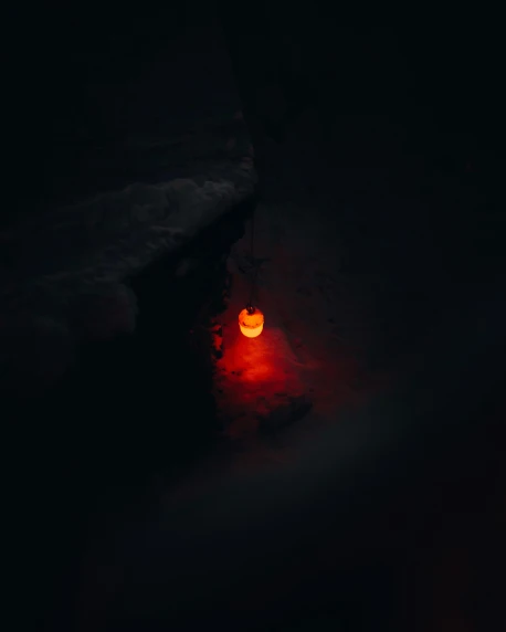 a candle that is glowing in the dark, by Attila Meszlenyi, unsplash contest winner, land art, red lunar eclipse, cave entrance, ☁🌪🌙👩🏾, shot from above