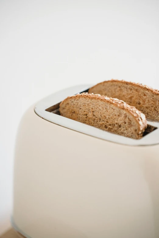 a toaster with two slices of bread in it, by Will Ellis, unsplash, minimalism, beige mist, glossy white, 4l, 王琛