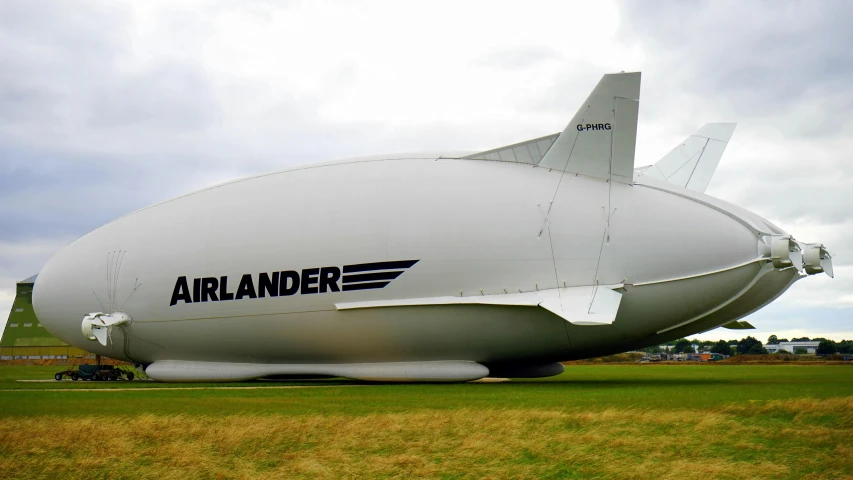 a large white airplane sitting on top of a lush green field, giant airships in the sky, in scotland, on display ”, spacehip lands