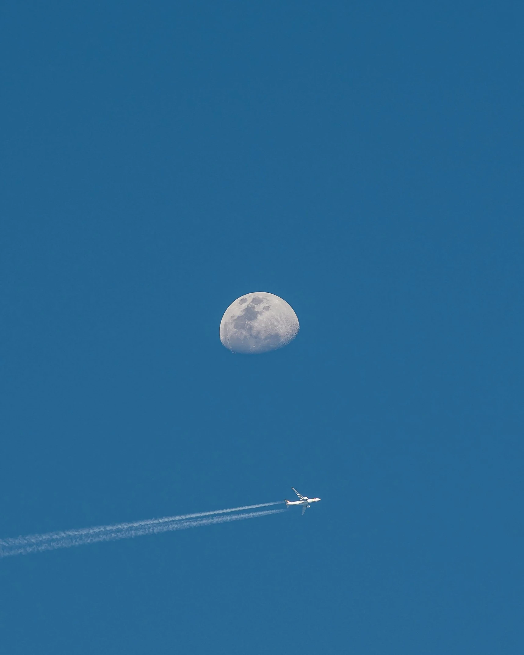 a plane flying in the sky with the moon in the background, pexels contest winner, minimalism, cloudless blue sky, thumbnail, may)