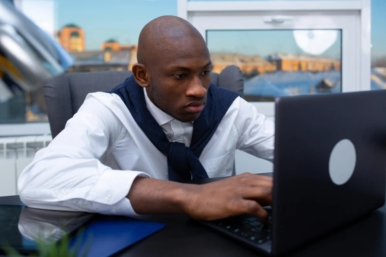 a man sitting at a desk using a laptop computer, inspired by Gerard Sekoto, pexels contest winner, bottom angle, curious, atiba jefferson, avatar image