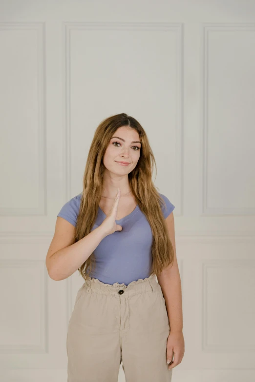 a woman standing in front of a white wall, pointing at the camera, pokimane, promo image, calmly conversing 8k