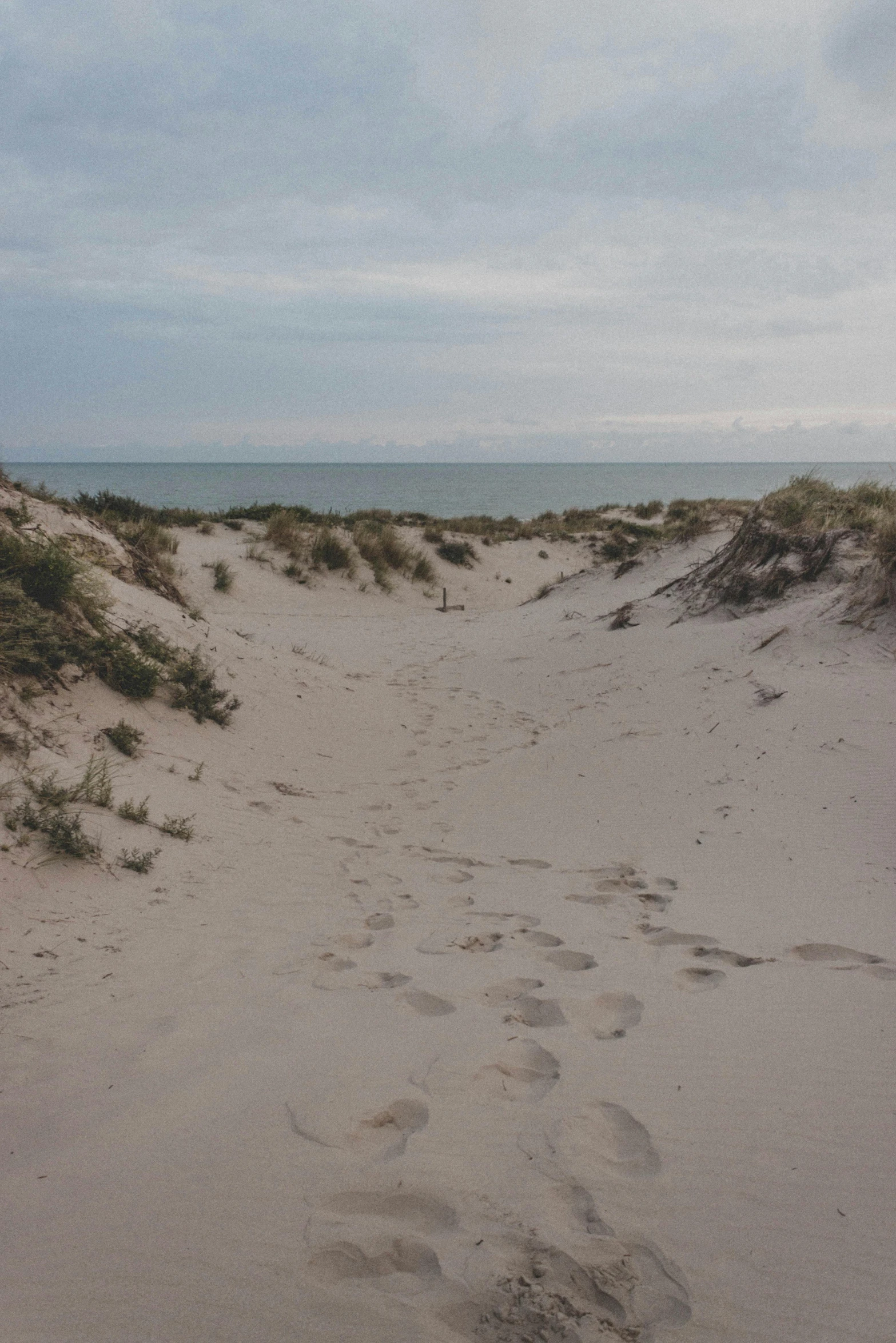 a sandy beach with footprints in the sand, by Jacob Toorenvliet, graafland, 8 k -, bunkers, late summer evening