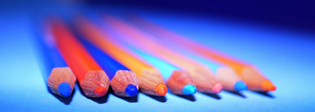 a group of colored pencils sitting on top of a blue surface, a color pencil sketch, by Jan Rustem, pexels contest winner, blue and orange lighting, indigo rainbow, long exposure ; sharp focus, ilustration