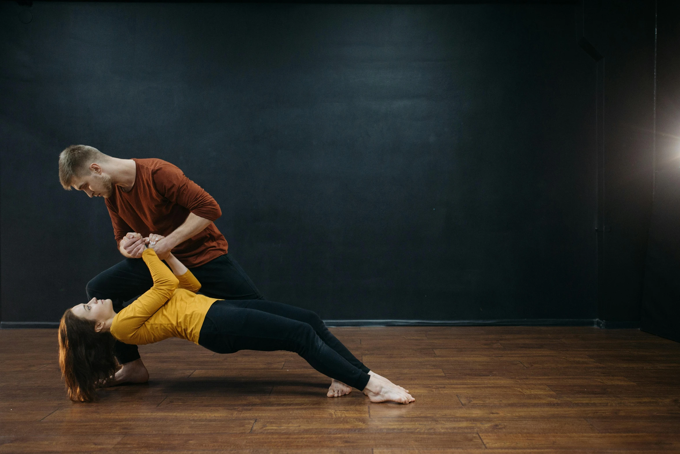 a man and woman doing a handstand in a dance studio, a portrait, by Nina Hamnett, unsplash, arabesque, background image, ochre, woman holding another woman, lachlan bailey