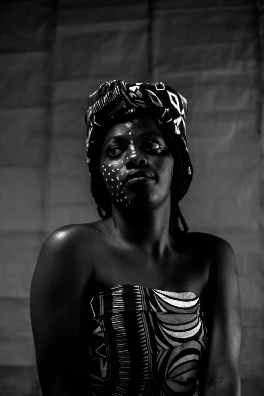 a woman in a black and white photo, by Lily Delissa Joseph, afrofuturism, wearing war paint, (night), mamou - mani, traditional photography