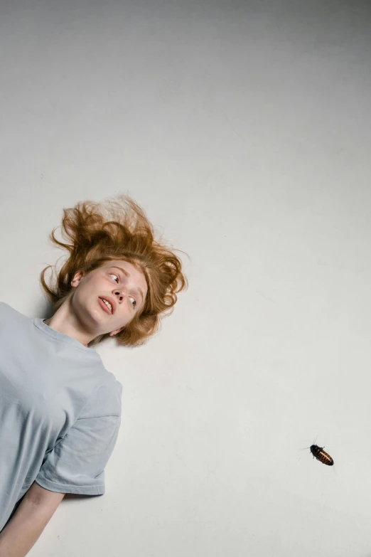 a woman throwing a frisbee in the air, an album cover, by Leo Leuppi, pexels contest winner, hyperrealism, ginger hair, patricia piccinini, waking up, laying down