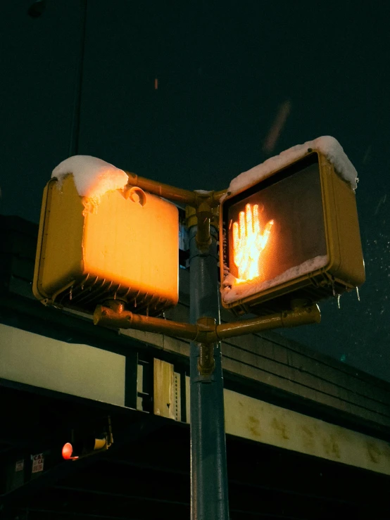 a traffic light with a hand print on it, an album cover, inspired by Elsa Bleda, unsplash, winter, fire lit, in tokio, broken signs
