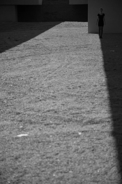 a black and white photo of a person walking down a sidewalk, postminimalism, late afternoon sun, ( ( abstract ) ), a park, crawling on the ground