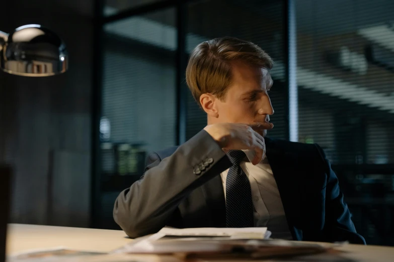 a man in a suit sitting at a desk, by Dietmar Damerau, unsplash, realism, still image from tv series, mid night, calmly conversing 8k, side profile shot